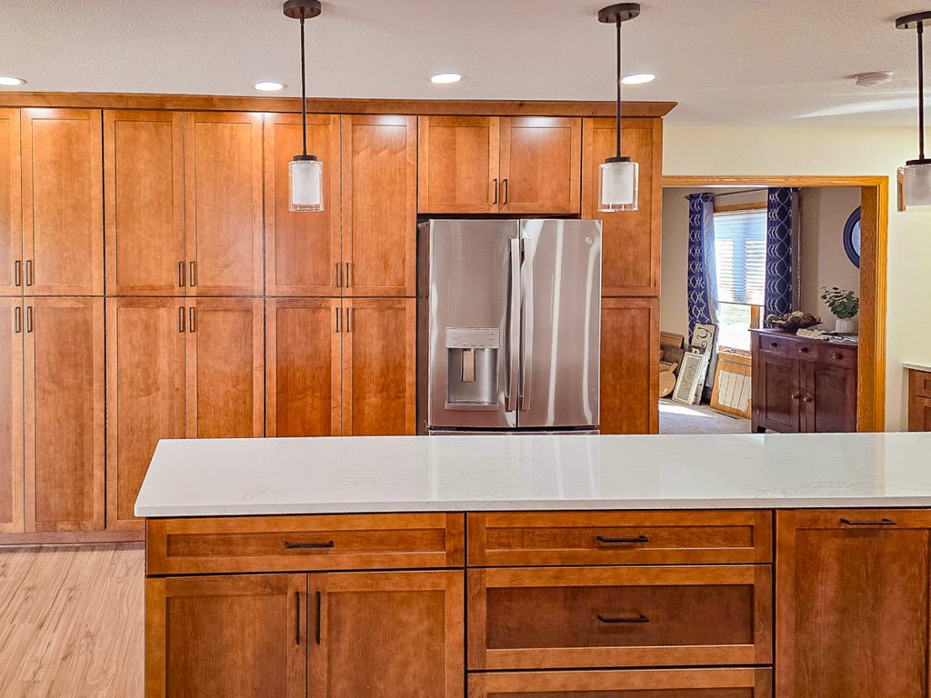 Warm Transitional - Elevated Designs: view of full wall of wood cabinets from behind the kitchen island
