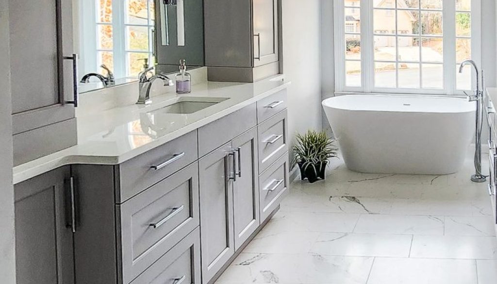 Timeless Master Bath - Elevated Designs: View of vanity area and storage with white tub in background