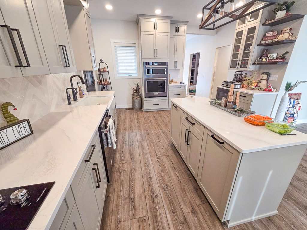 Modern Farmhouse - Elevated Designs: Kitchen with white cabinets, wood floors and stainless steel oven
