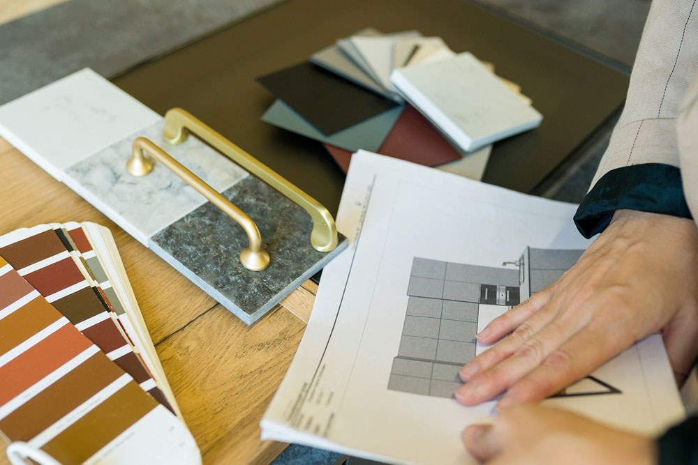 Elevated Designs Other Designs person reviewing kitchen color, tile and hardware samples