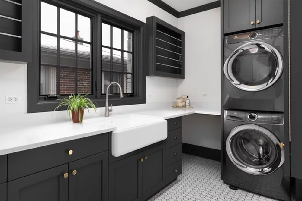 ElevatedDesigns_SeamlessProcess laundry room with black cabinets white marble top and black laundry machines.